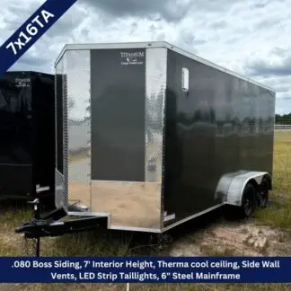 Black enclosed cargo trailer with diamond-plate front and dual axles, parked on grass; Titan Cargo logo visible at the nose.