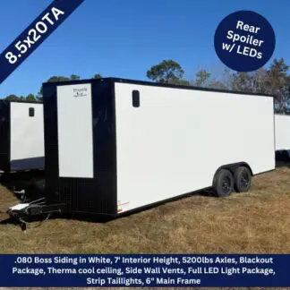 White enclosed dual-axle cargo trailer on a field, with black front and rear spoiler/LED lights at the back, 8.5x20TA size label visible