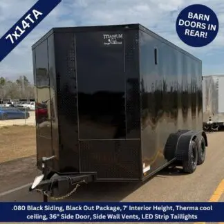Black enclosed cargo trailer with tandem axles and rear barn doors, shown on a dealership lot.