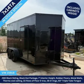 Black enclosed cargo trailer with dual axles on a concrete lot; front hitch visible and glossy finish.