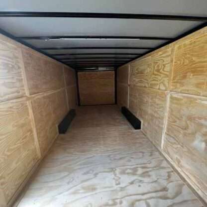 A long trailer with many wooden walls and floor.