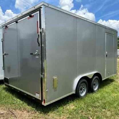 A silver trailer parked in the grass.