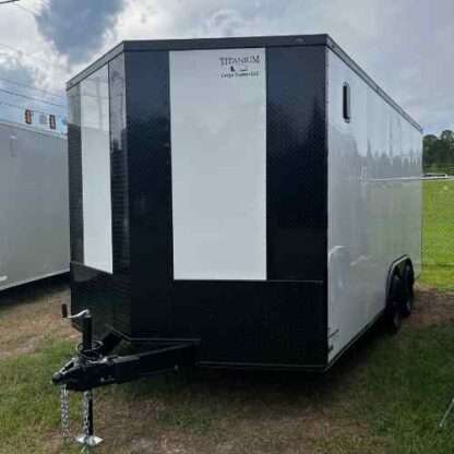 A black and white trailer parked in the grass.