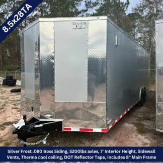 Silver diamond-plate enclosed cargo trailer (8.5x28TA) with hitch, parked on dirt; 7' interior height and side vents visible; red/white reflector tape along the lower edge.